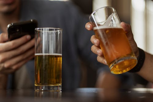 Person Holding Clear Drinking Glass With Beer