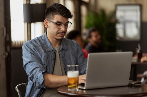 Man Working on Laptop with Glass of Beer