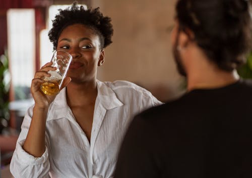 Woman Drinking and Talking to Man