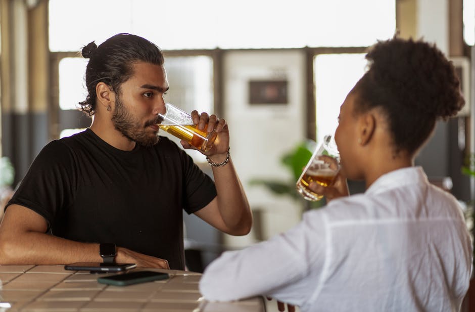 Two adults enjoying drinks and conversation at a bar setting.