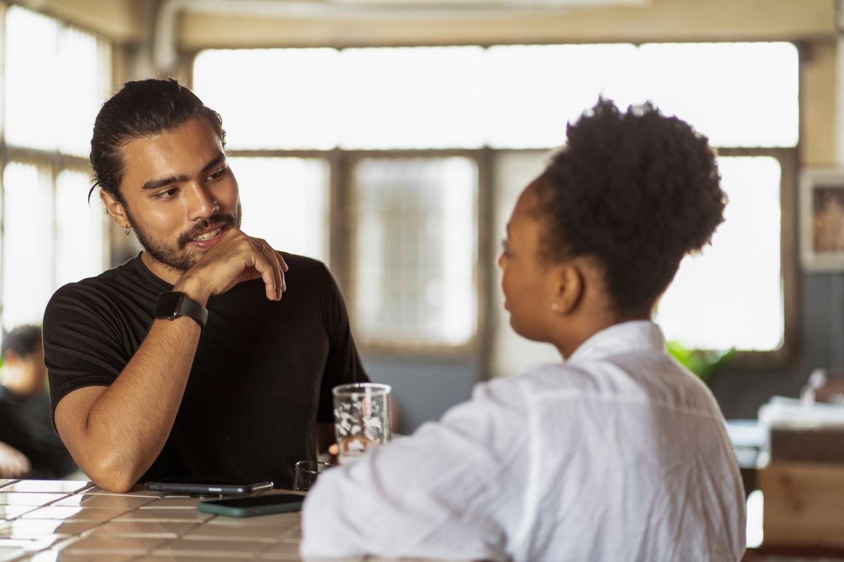 Un hombre y una mujer conversando e intercambiando opiniones en interior