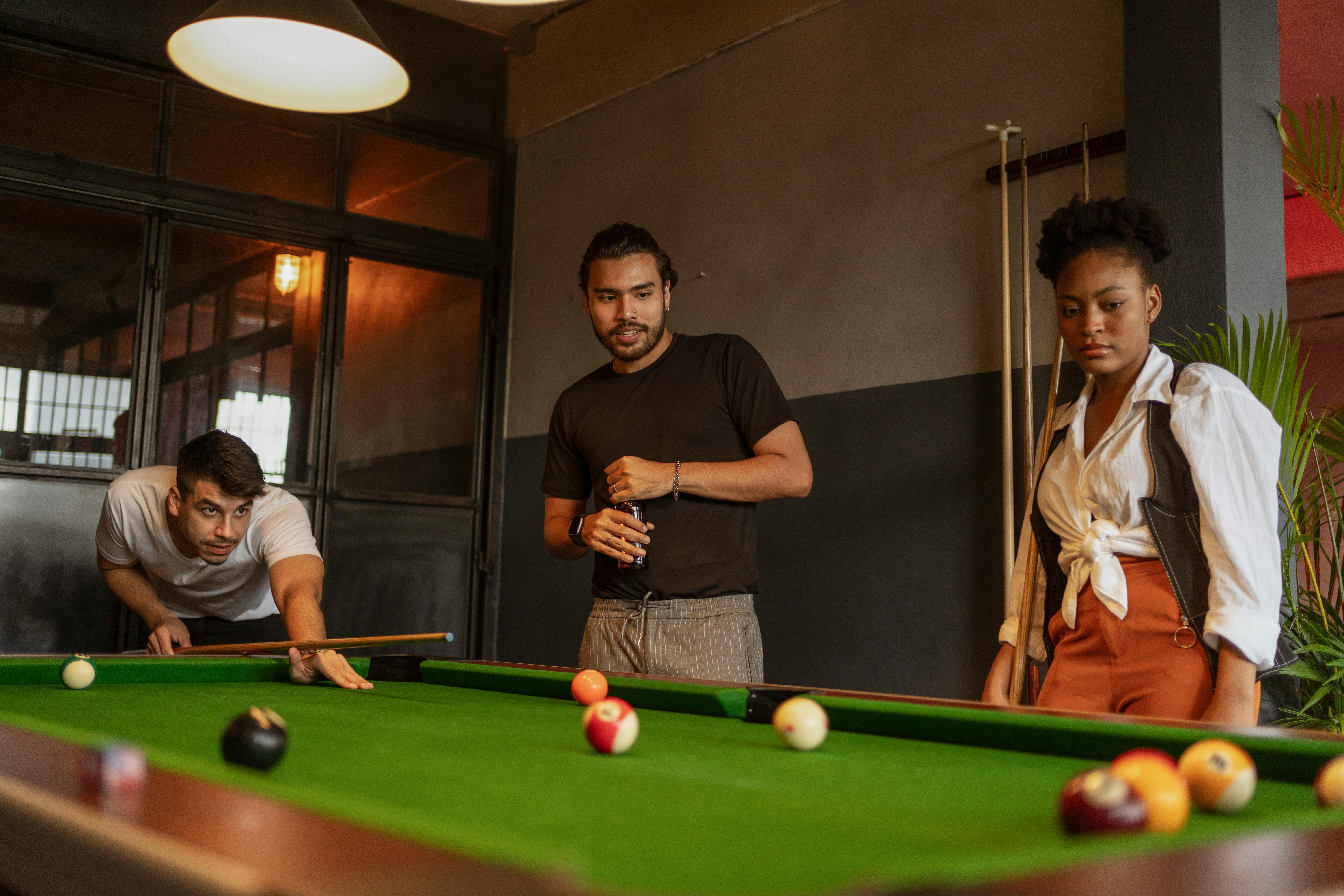 friends playing snooker in club