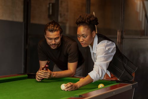 Free Man and Woman Playing Billiard and Drinking Beer Stock Photo