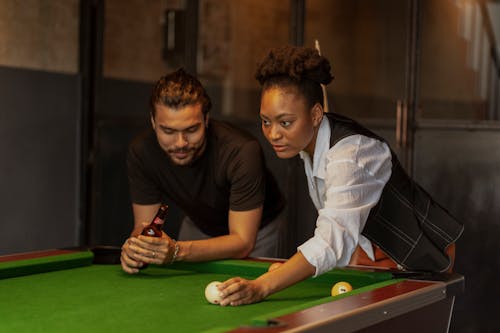 Man and Woman Playing Billiard and Drinking Beer