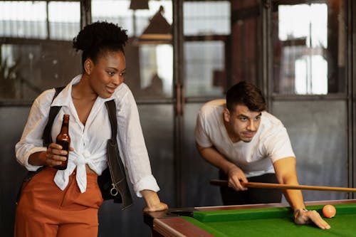 Man and Woman Playing Billiard and Drinking Beer 