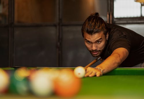 Free Man Hitting the Balls with a Club in a Billiard Game  Stock Photo