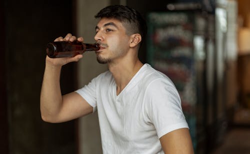 A Man Drinking Beer from a Bottle