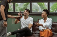 一群朋友在室内喝着啤酒，微笑着享受彼此的陪伴，放松身心