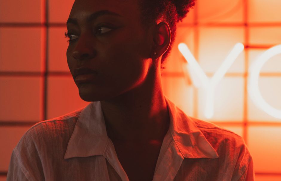 A striking portrait of a woman in neon lighting, creating a moody and artistic atmosphere.