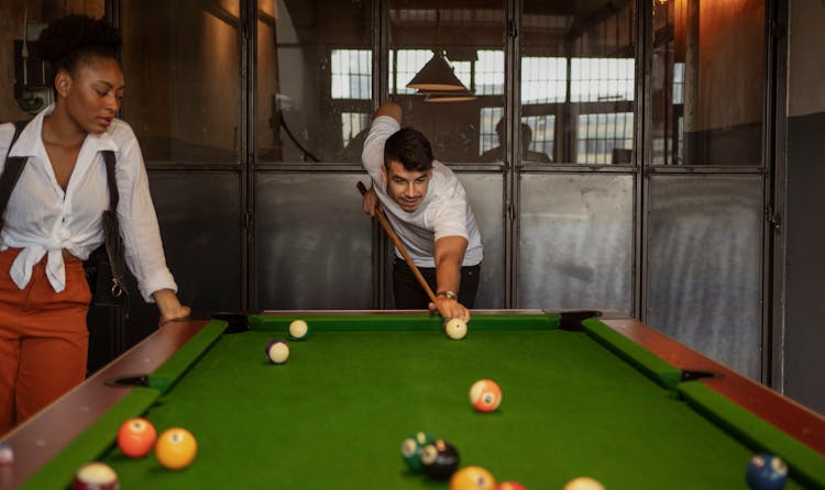 Couple Playing Snooker At Bar