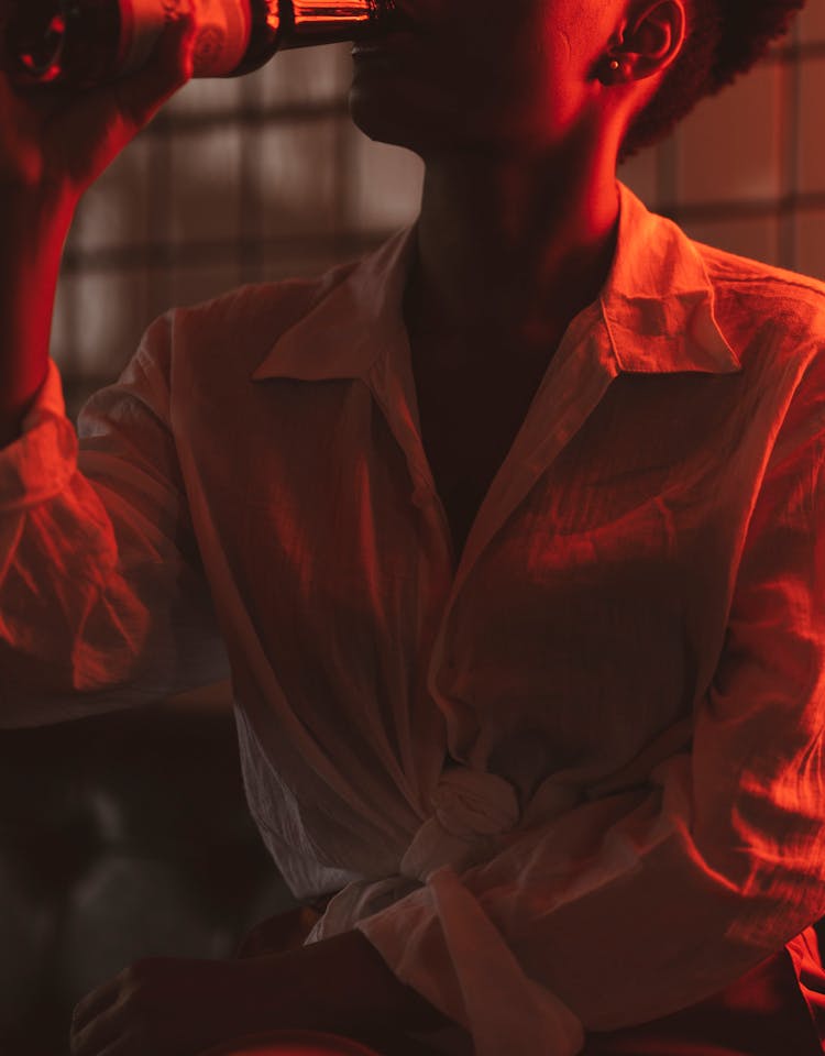 Woman Drinking Beer In Red Neon Light 