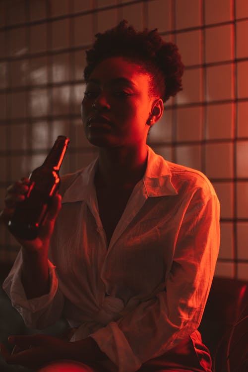 Woman in Bar Drinking Beer from Bottle