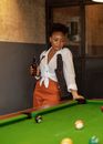 Woman in White Blazer and Brown Pants Standing Beside Billiard Table