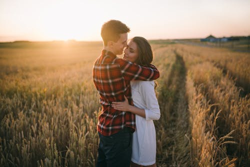 Couple Hugging and Smiling on a Field 