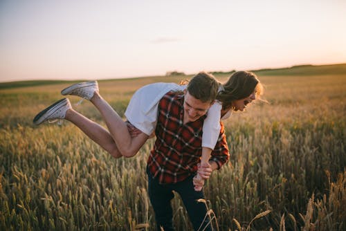 A Man Lifting a Woman in the Field