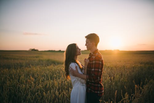 Man En Vrouw Kussen Op Grasveld Tijdens Zonsondergang