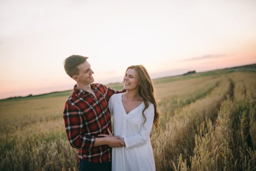 Man and Woman Standing on Farm Field