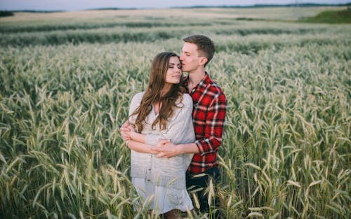 Мужчина и женщина, стоящие на поле зеленой травы