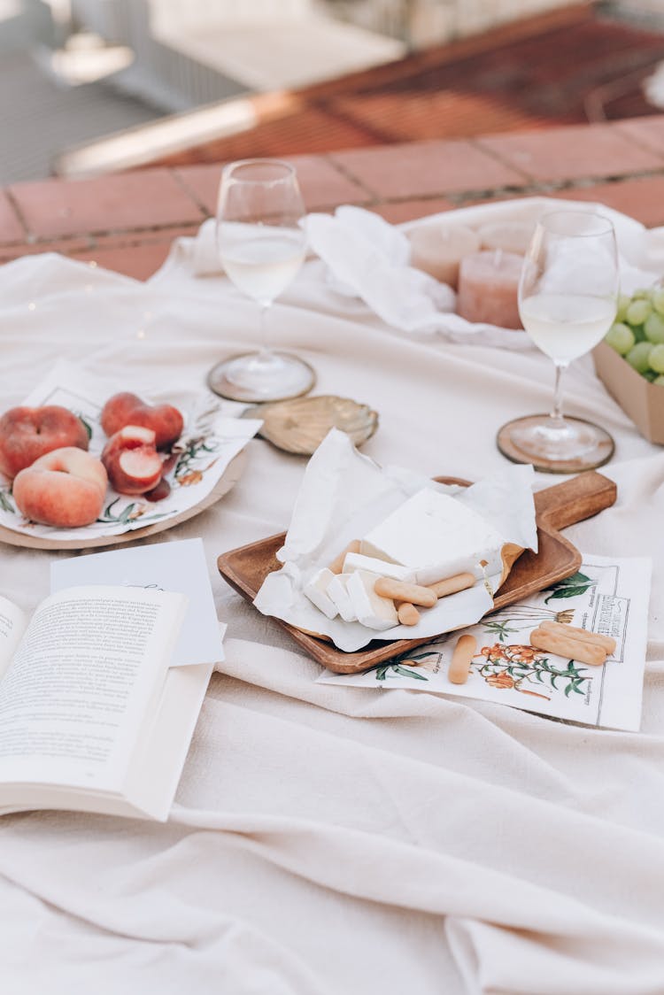 Food And Drinks Over White Picnic Blanket