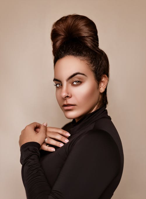 Stylish woman with nose ring in studio