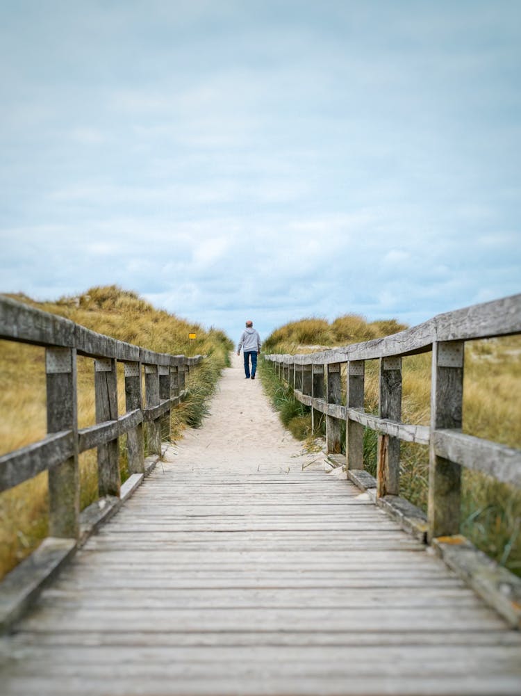 Man Walking Towards The Beach Entrance 