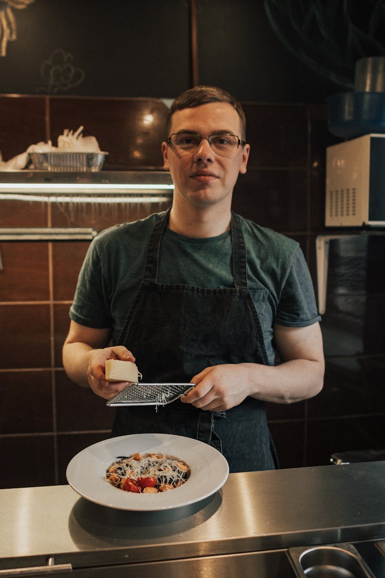 Man In Crew Neck T-shirt Grating Cheese