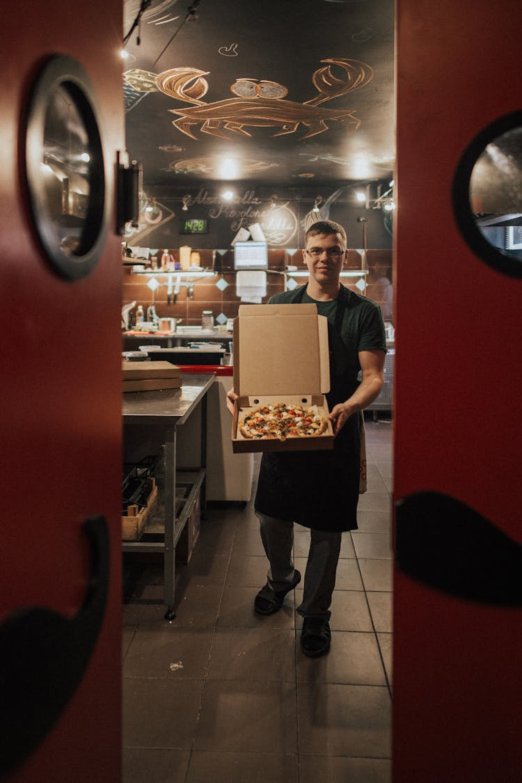 A Chef Holding A Box Of Pizza