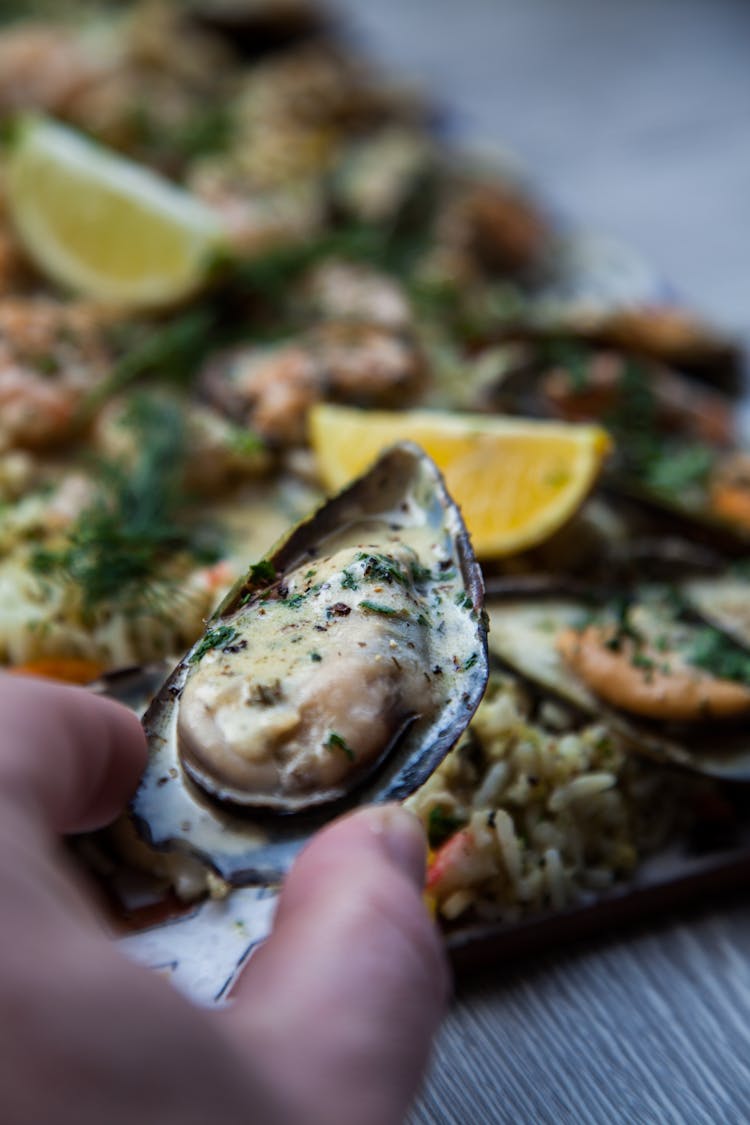 Person Holding A Cooked Mussel