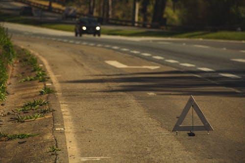 Car on road with warning sign in evening