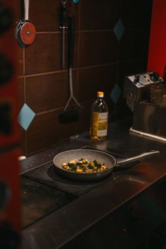 A cozy kitchen scene with vegetables frying in a pan on a stove.