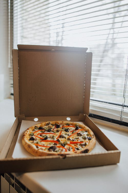 Pizza in a Box Beside a Window