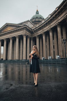 阴天，一名围着围巾、身着黑色连衣裙的女士，站在标志性的喀山大教堂前