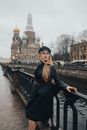 一位金发时尚女子在圣彼得堡的血洒救世主教堂附近摆姿势