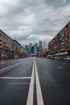阴沉的天空下，宽阔的废弃道路和高耸的城市建筑，构成了一幅戏剧性的城市景观