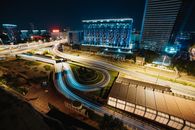 夜晚的城市景观充满活力，展示着璀璨的光路和高耸的摩天大楼