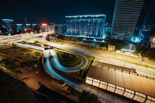 夜晚的城市景观充满活力，展示着璀璨的光路和高耸的摩天大楼