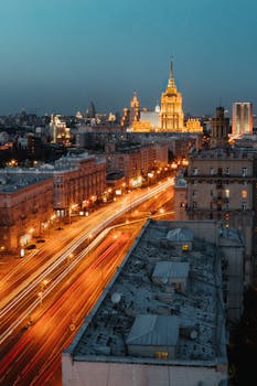 A mesmerizing view of the city skyline illuminated at night with glowing traffic trails creating an urban symphony.