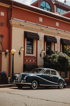 一辆经典老爷车停在优雅的建筑旁，散发着永恒的魅力