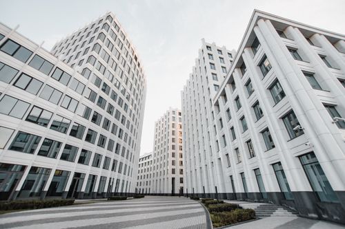Free View of tall modern white buildings with glass windows forming a distinctive architectural style. Stock Photo