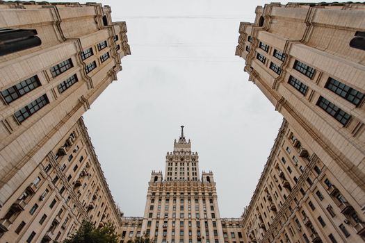 低角度拍摄高耸的城市建筑，天空多云，画面充满戏剧性
