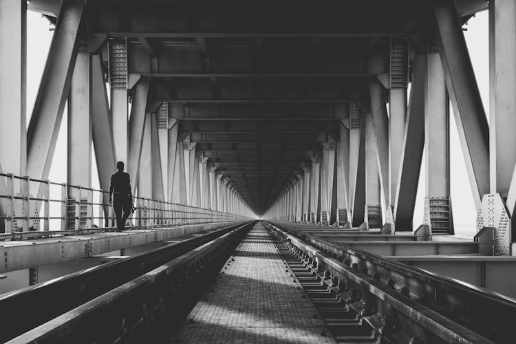 Back View Of A Person Walking On The Side Of Railway Track 