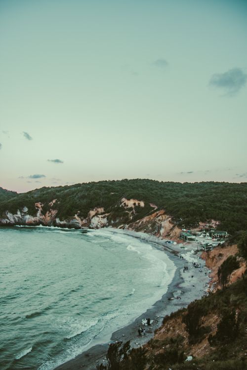 Free A breathtaking aerial view of Türkiye's coastline at sunset, showcasing waves, cliffs, and lush greenery. Stock Photo