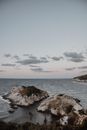 Brown Rock Formation on Sea Under White Clouds