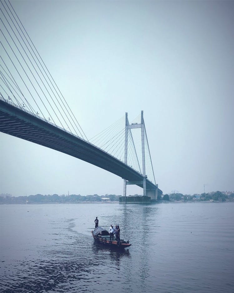 Boat Sailing On A Body Of Water Under The Bridge 