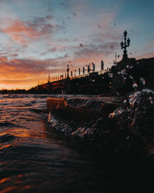 Body of Water with Bridge during Sunset