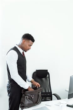 商人站在现代化的办公室里，整理着他的皮包