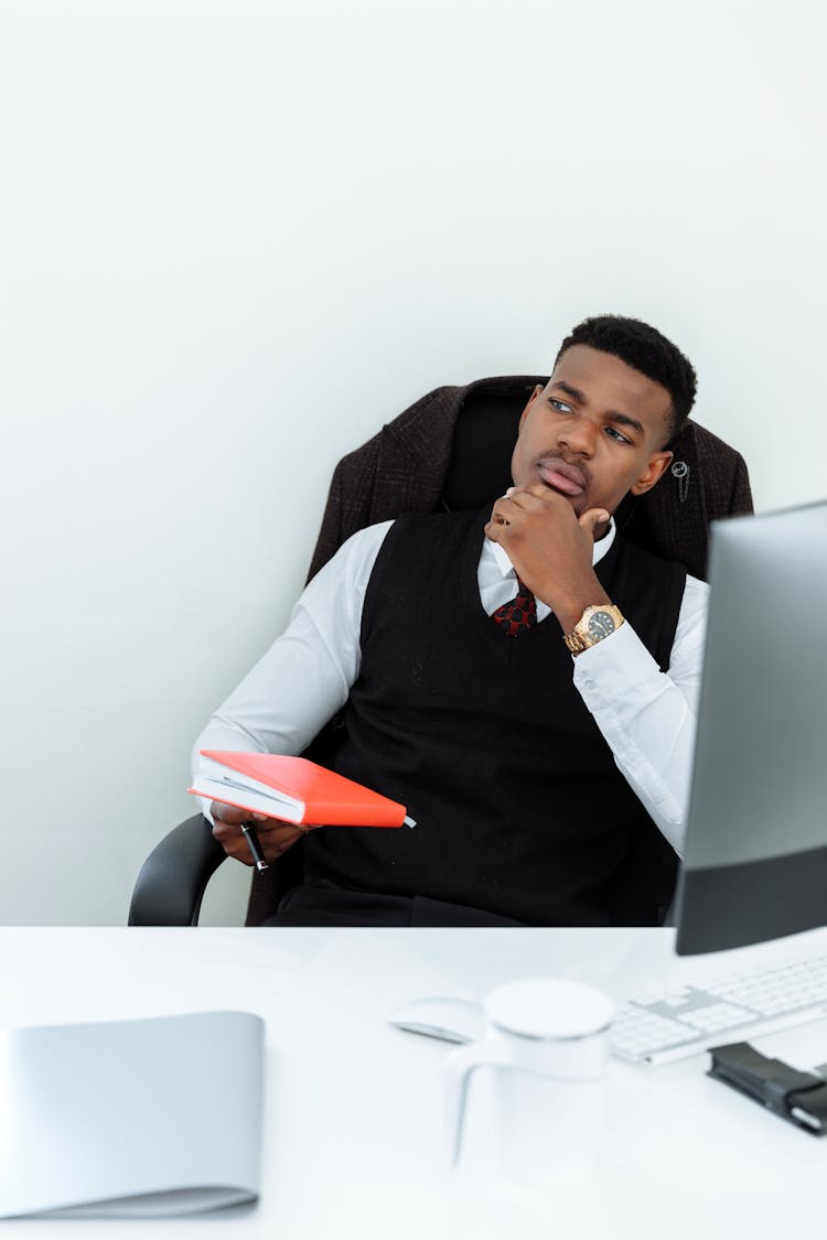 Man Wearing A Suit Holding A Notebook