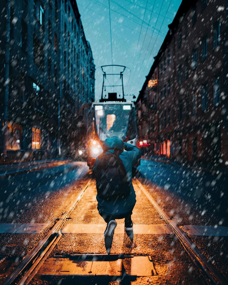 A Person Jumping In Front Of An Approaching Train While Snowing