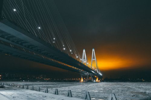 Free Illuminated Bolshoy Obukhovsky Bridge spanning icy Neva River in Saint Petersburg during winter night. Stock Photo