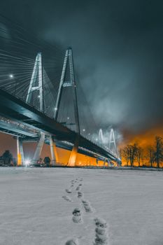夜晚，白雪皑皑的桥梁上脚印清晰，散发着凉爽的冬日气息，场景富有戏剧性